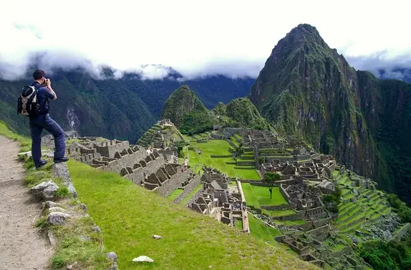 Turista tomando una foto a la antigua ciudadela inca de Machu Picchu, en Perú.